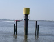 Das Bild zeigt einen Wasserstandspegel an einem Dalben, der im Wasser steht Das Bild zeigt einen Wasserstandspegel an einem Dalben, der im Wasser steht