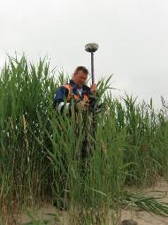 Das Bild zeigt einen Mitarbeiter bei der terrestrischen Vermessung mit GPS